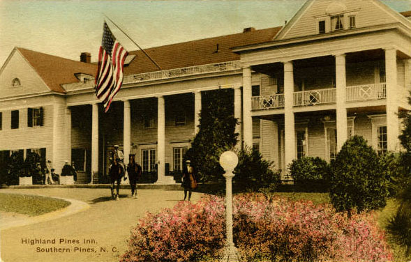 Postcard of the Highland Pines Inn in Southern Pines, N.C. showing a two-story inn with horses in front and an American flag waving in the wind.