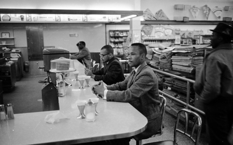 Photo of African American sitting at a counter.