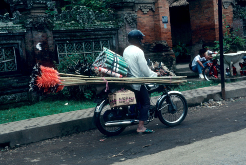 Man sells feather dusters from motorcycle