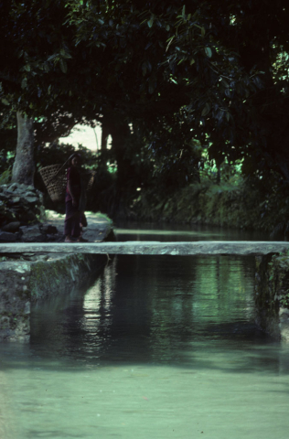 Woman crossing a stone bridge