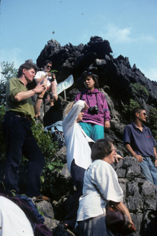 Tourist group of seven people standing on steep rocks