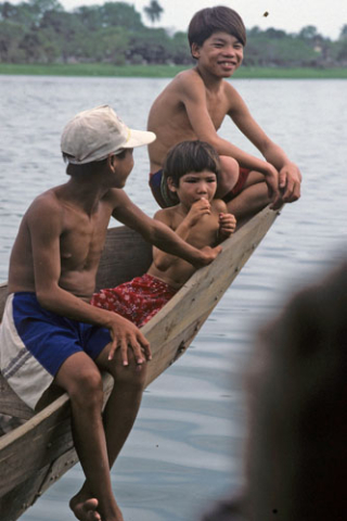 Three boys sitting on a boat prow in the Perfume River near Hue
