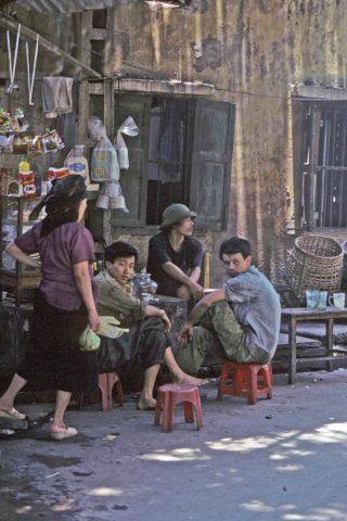 Three men sitting at a streetside cafe in Hanoi, Vietnam