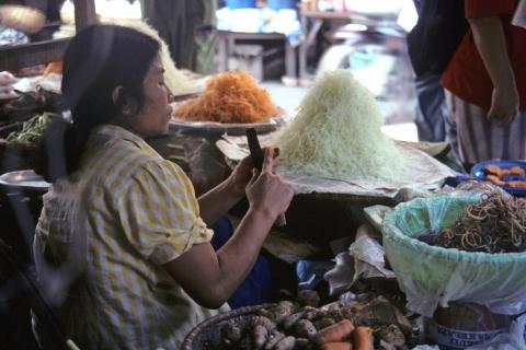 Woman selling noodles at outdoor market in Hanoi