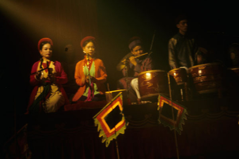 Women and men musicians accompany a water puppet performance in Hanoi