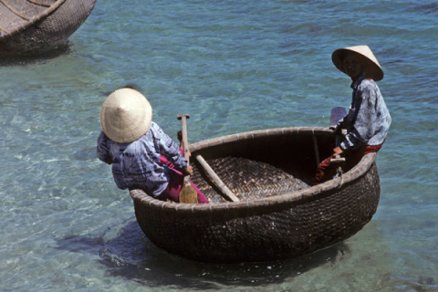 Two people paddle a round basketry boat near Nha Trang