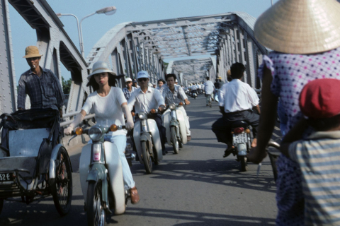 Motorcycle and bycycle traffic crossing bridge at Hue
