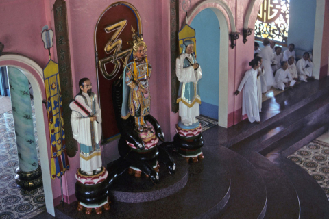 Painted statues including Victor Hugo on platform in Cao Dai temple at Tay Ninh