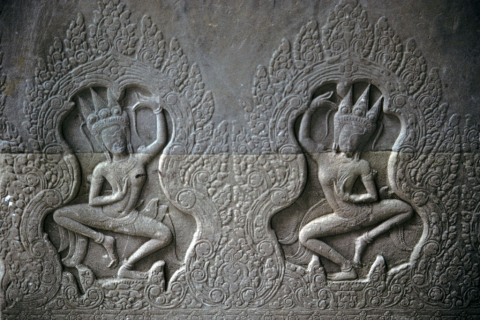 Two dancing female deities with spiked crowns carved in low relief at Angkor Wat
